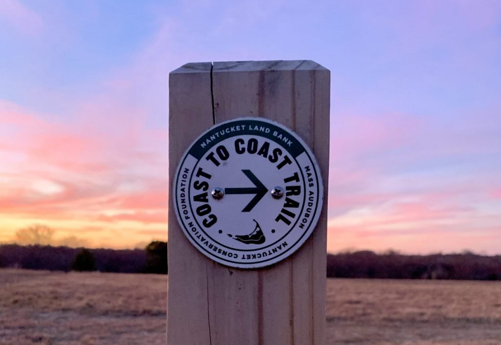 Coast to Coast trail marker at sunset.