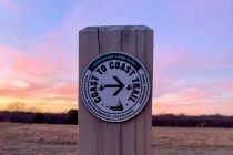 Coast to Coast trail marker at sunset.